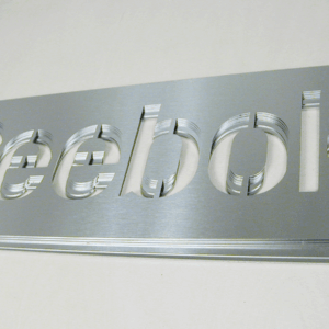 Stack of custom logos cut from thin stainless steel